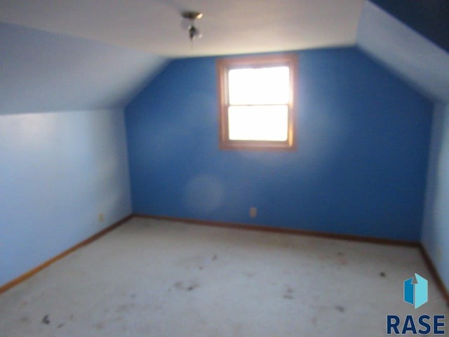 additional living space featuring carpet flooring and lofted ceiling