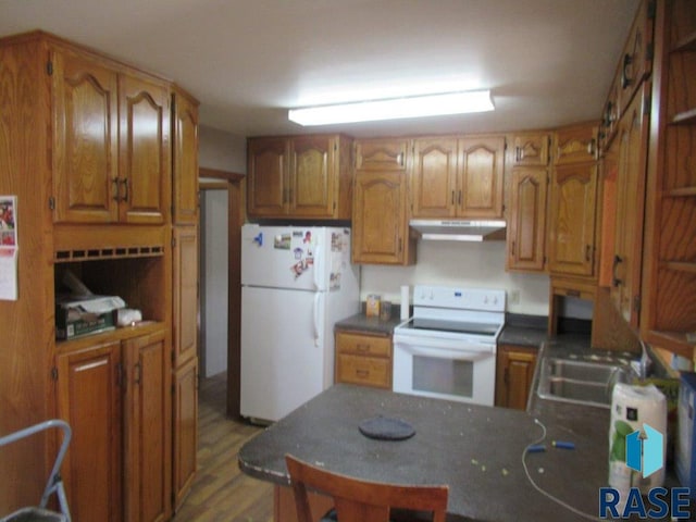 kitchen with sink, white appliances, and light wood-type flooring