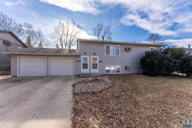 view of front of property featuring a wall mounted air conditioner and a garage