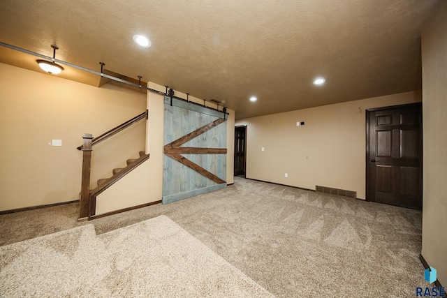 interior space featuring a textured ceiling and a barn door