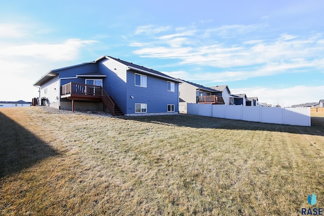 rear view of house with a lawn and a deck