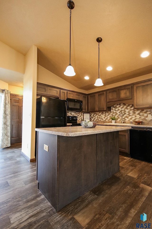 kitchen with pendant lighting, dark hardwood / wood-style flooring, vaulted ceiling, and black appliances