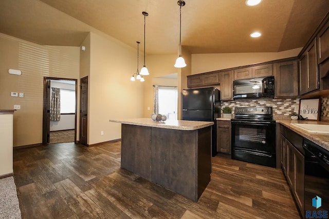 kitchen featuring pendant lighting, lofted ceiling, black appliances, dark brown cabinets, and a kitchen island