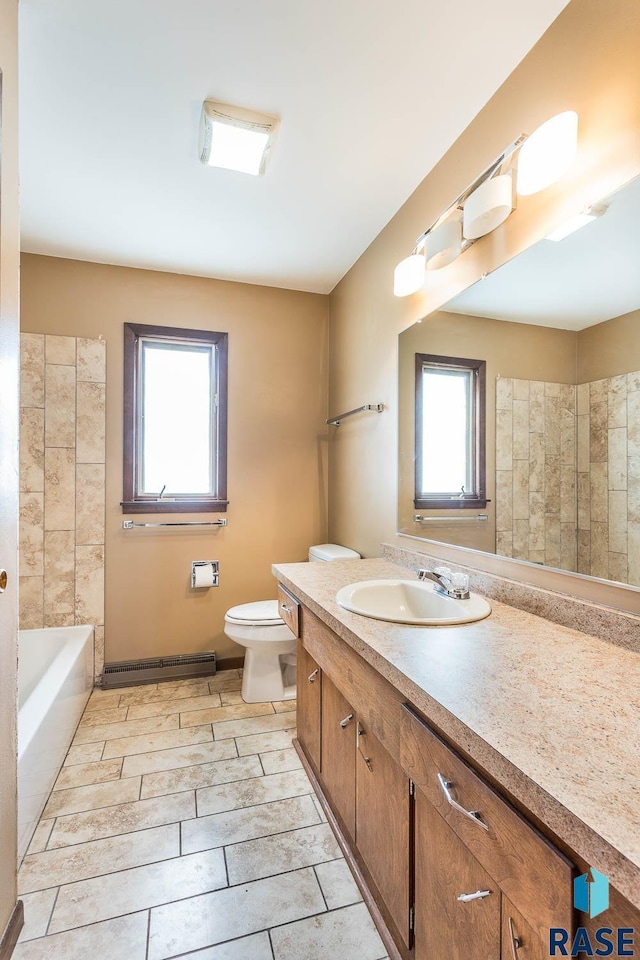 bathroom featuring vanity, toilet, baseboard heating, and a washtub