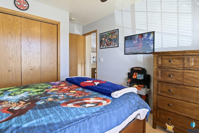 carpeted bedroom with a textured ceiling and a closet