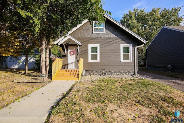 bungalow-style house featuring a front lawn