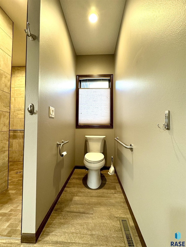 bathroom with hardwood / wood-style floors and toilet