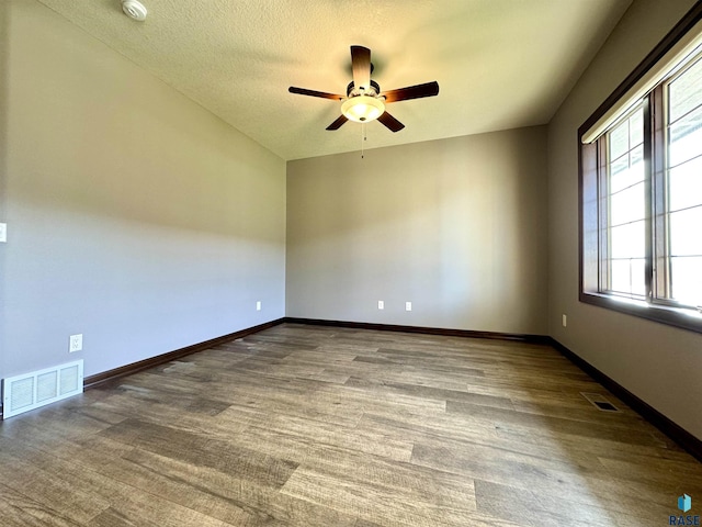 unfurnished room with ceiling fan and a textured ceiling