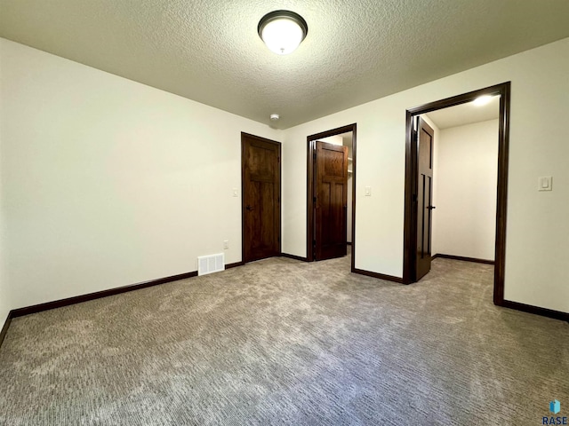 unfurnished bedroom featuring a textured ceiling and light colored carpet