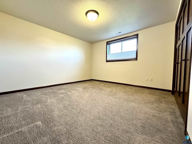 spare room with a textured ceiling and carpet