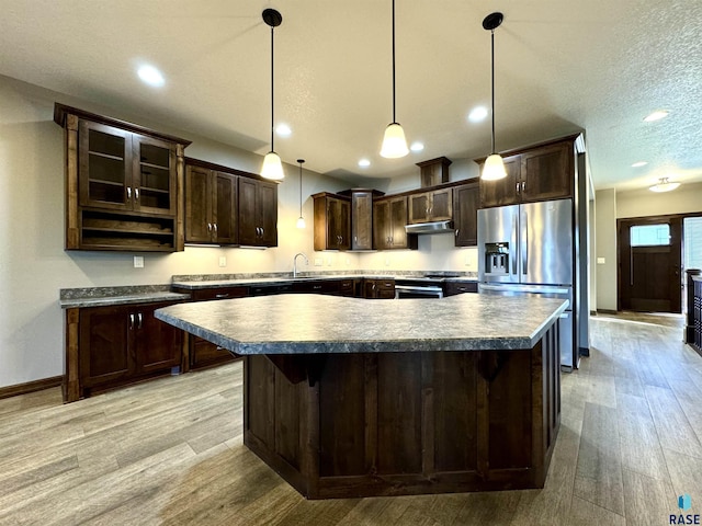 kitchen featuring dark brown cabinets, hanging light fixtures, light hardwood / wood-style flooring, and stainless steel appliances