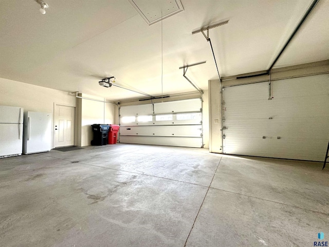 garage with white fridge and a garage door opener