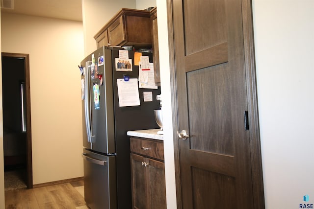 kitchen featuring stainless steel fridge and light hardwood / wood-style flooring