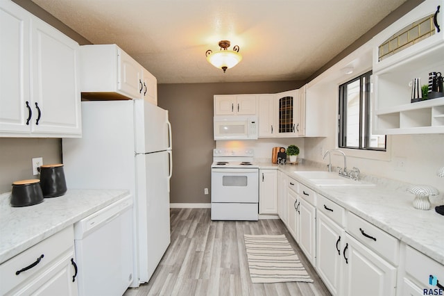 kitchen featuring white appliances, sink, light wood-type flooring, light stone counters, and white cabinetry