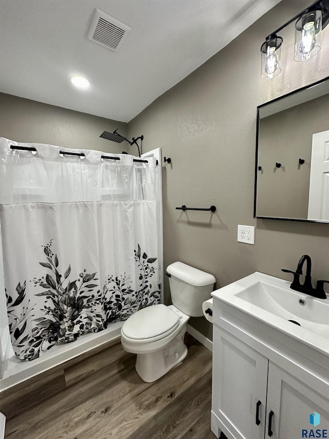 bathroom featuring vanity, hardwood / wood-style floors, curtained shower, and toilet