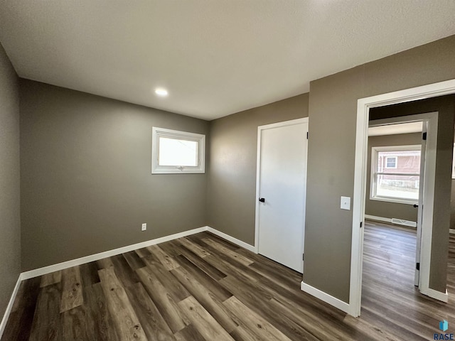 unfurnished bedroom with dark hardwood / wood-style flooring