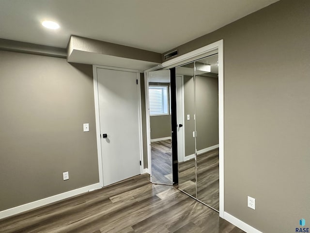 unfurnished bedroom featuring wood-type flooring and a closet