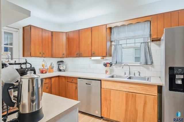 kitchen featuring backsplash, sink, light wood-type flooring, and stainless steel appliances