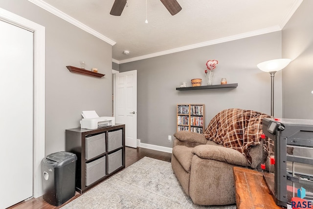 sitting room featuring ceiling fan, wood-type flooring, and crown molding