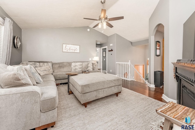 living room with light hardwood / wood-style flooring, ceiling fan, and lofted ceiling