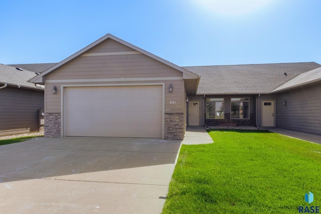 ranch-style house featuring a garage and a front lawn