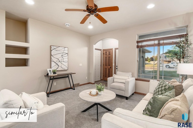 carpeted living room with ceiling fan