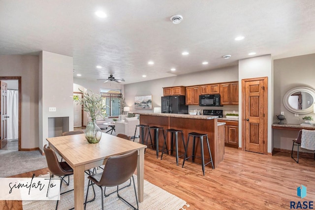 dining room with a textured ceiling, light hardwood / wood-style flooring, and ceiling fan