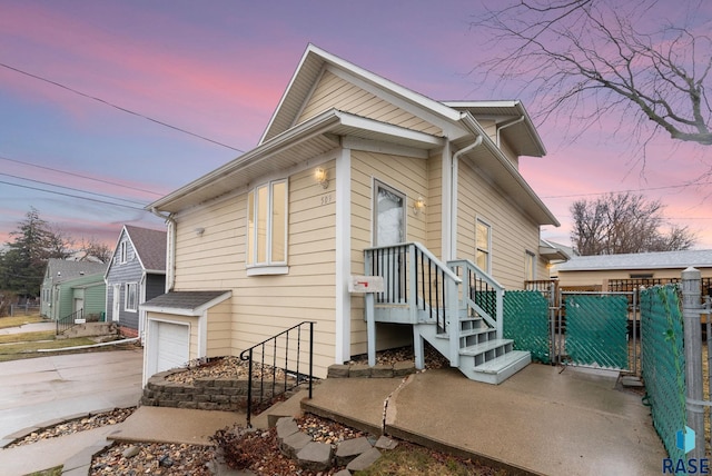 view of front of property with fence, an attached garage, driveway, and a gate