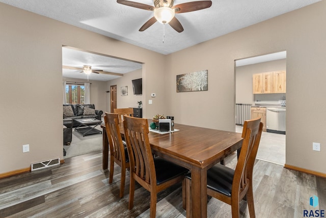 dining room featuring ceiling fan, hardwood / wood-style floors, and a textured ceiling