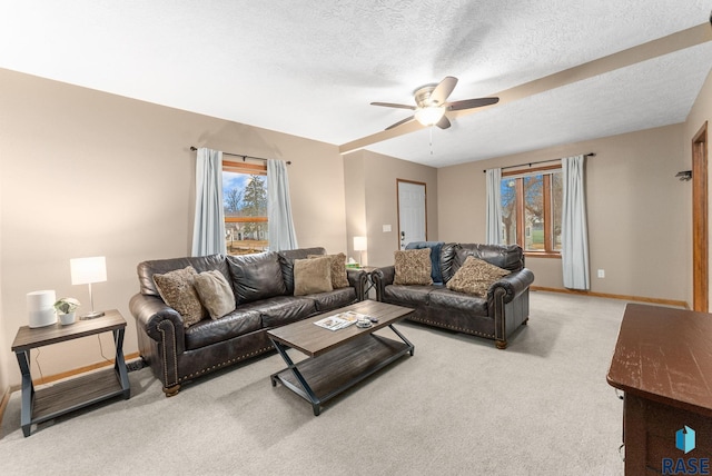 living room featuring ceiling fan, light colored carpet, and a textured ceiling