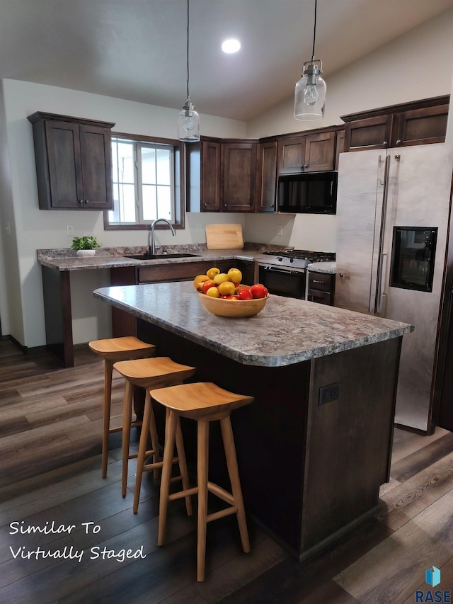 kitchen featuring stainless steel fridge, gas stove, sink, a center island, and lofted ceiling