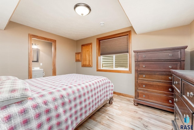 bedroom featuring light wood-type flooring and ensuite bath