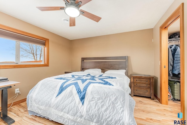 bedroom featuring ceiling fan, light hardwood / wood-style floors, and a closet