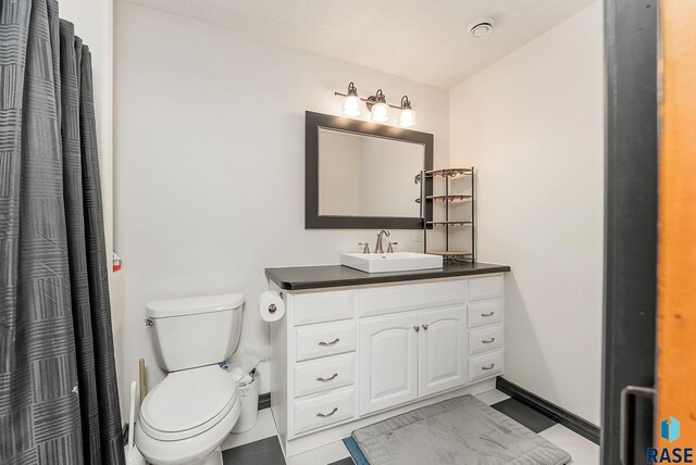 bathroom featuring tile patterned floors, vanity, and toilet