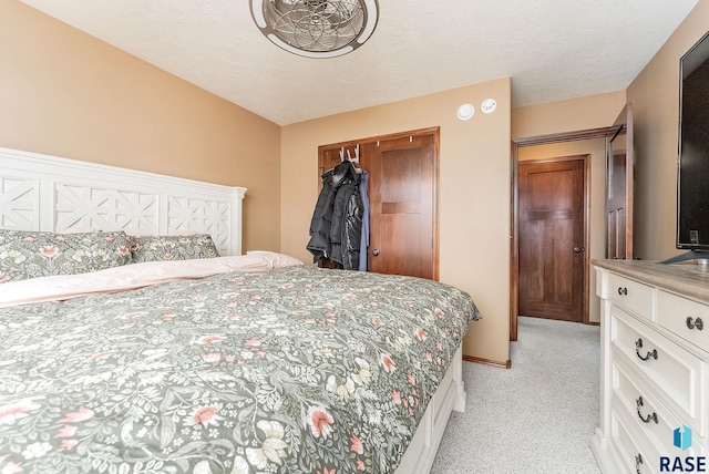 carpeted bedroom with a textured ceiling and a closet