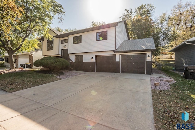 split foyer home with a garage and a front lawn