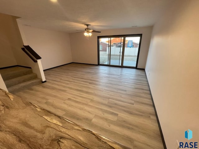 unfurnished living room with light hardwood / wood-style flooring and ceiling fan