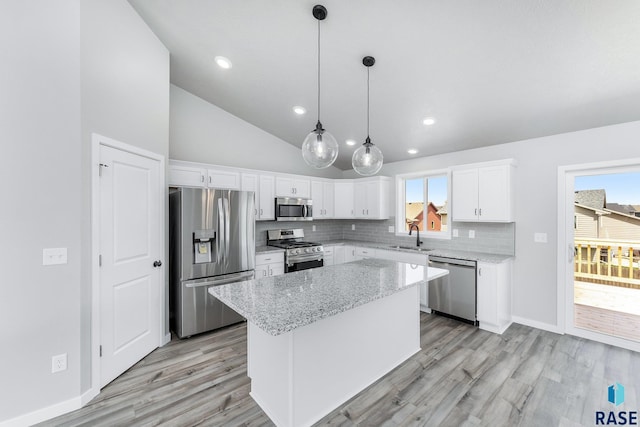 kitchen featuring sink, hanging light fixtures, stainless steel appliances, a kitchen island, and white cabinets