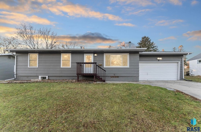 single story home featuring a lawn and a garage