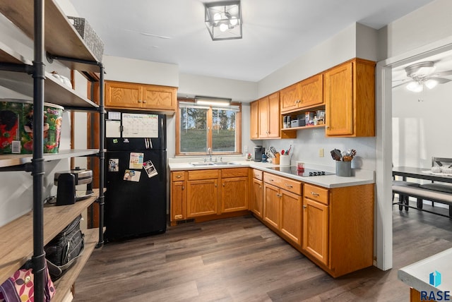 kitchen with sink, dark hardwood / wood-style floors, ceiling fan, and black appliances