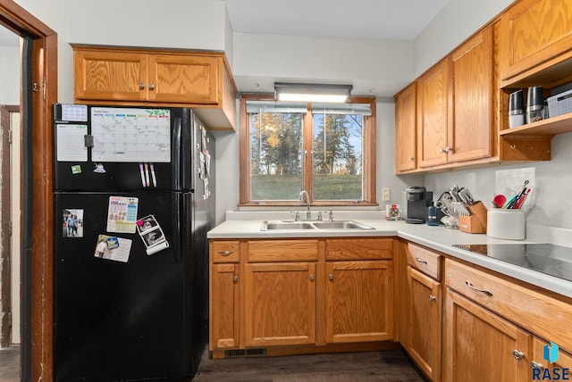 kitchen with dark wood-type flooring, sink, and black appliances