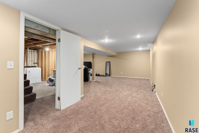 basement with washer / clothes dryer and light colored carpet