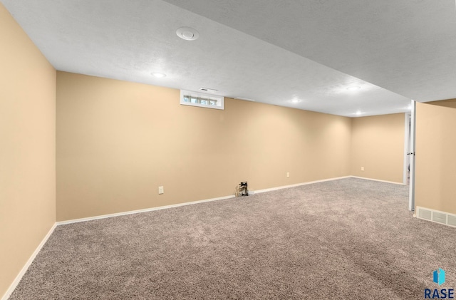 basement with carpet and a textured ceiling