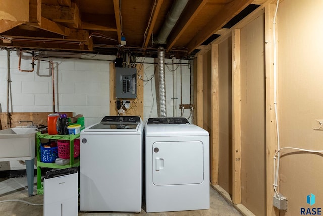 washroom featuring washing machine and clothes dryer, electric panel, and sink