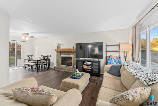 living room featuring ceiling fan, a fireplace, and dark hardwood / wood-style floors