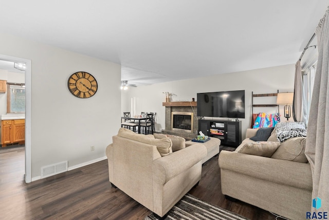 living room with ceiling fan, dark hardwood / wood-style flooring, and a fireplace