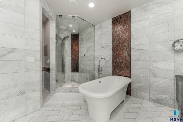 bathroom featuring separate shower and tub and tile walls