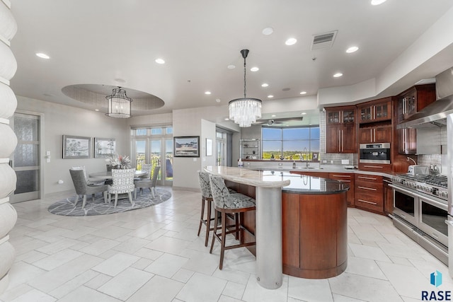 kitchen featuring an inviting chandelier, hanging light fixtures, dark stone countertops, tasteful backsplash, and stainless steel appliances