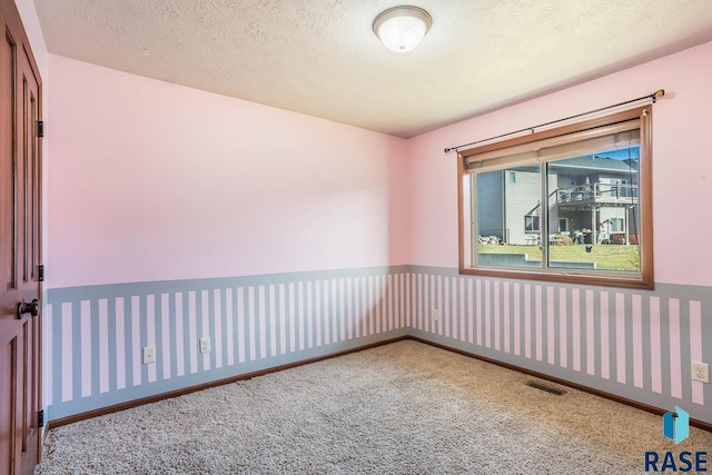 empty room featuring carpet floors and a textured ceiling