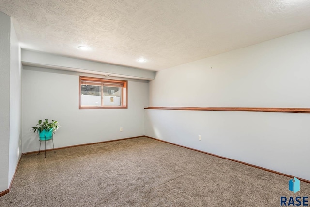 spare room featuring carpet floors and a textured ceiling